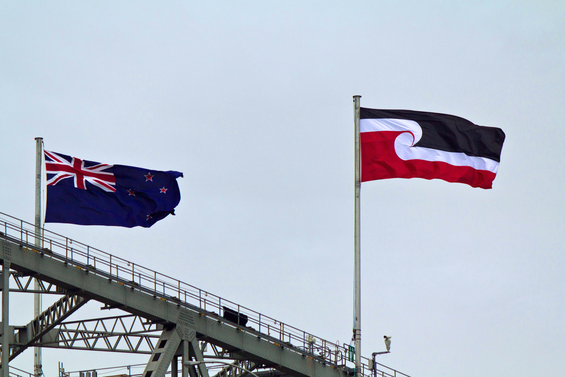 New Zealand's flag flies on top of Auckland's harbour bridge alongside the Tino Rangatiratanga flag.