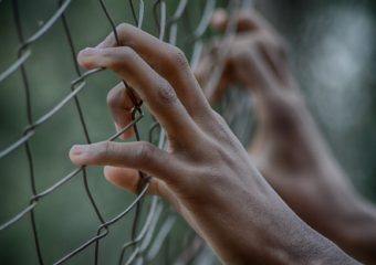 Stock photo of prisoner behind fence