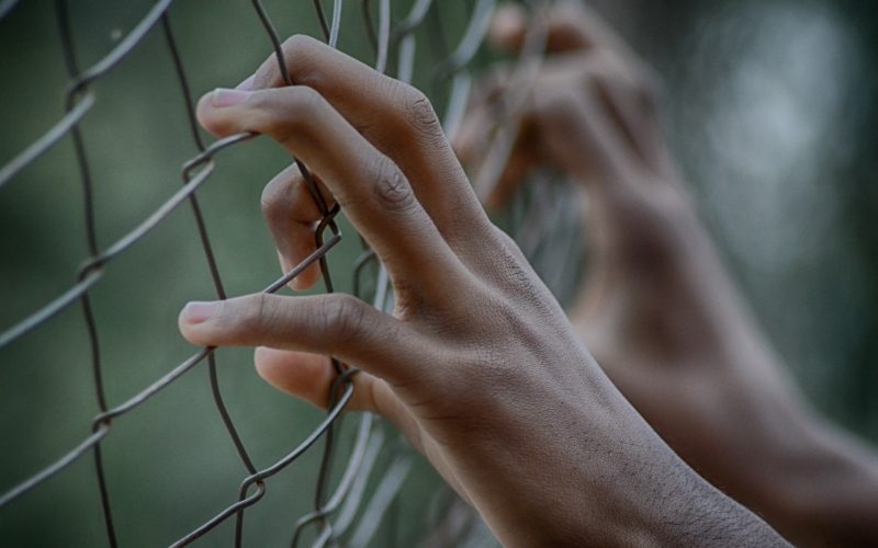 Stock photo of prisoner behind fence