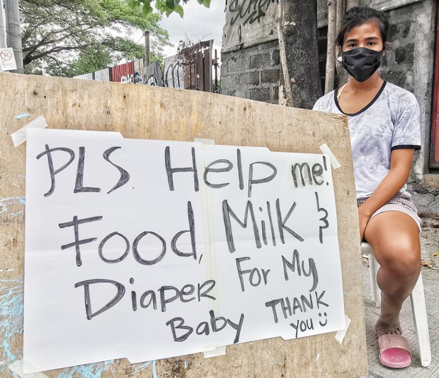 Abigail, 19 years old, asks for food, milk and diaper for her 8-month-old baby from motorists passing along Commonwealth Avenue in Fairview, Quezon City amid the enhanced community quarantine.