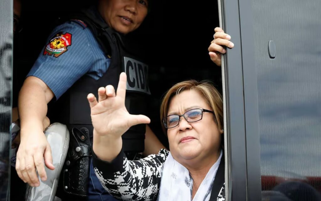 A policewoman guards Philippine Senator Leila de Lima as she raises a sign that means “Laban” (Fight), after appearing at court on drug related charges in Muntinlupa, Metro Manila, Philippines, on February 24, 2017. (Reuters / Erik De Castro)