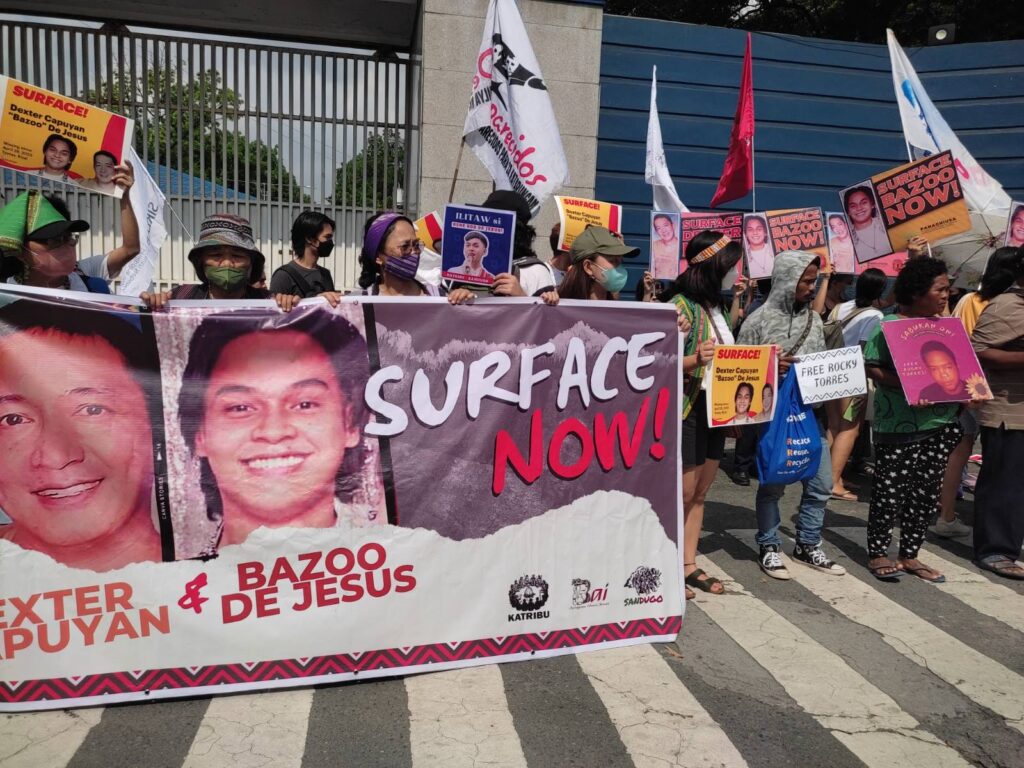 The families of Dexter Capuyan and Bazoo de Jesus, along with activists, hold a protest action at the Camp Crame police headquarters to demand the resurfacing of the two missing activists.