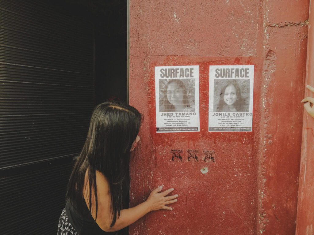 A passerby looks at missing posters for Jhed Tamano and Jonila Castro. (Photo: Althea Jana Trinidad/Facebook)