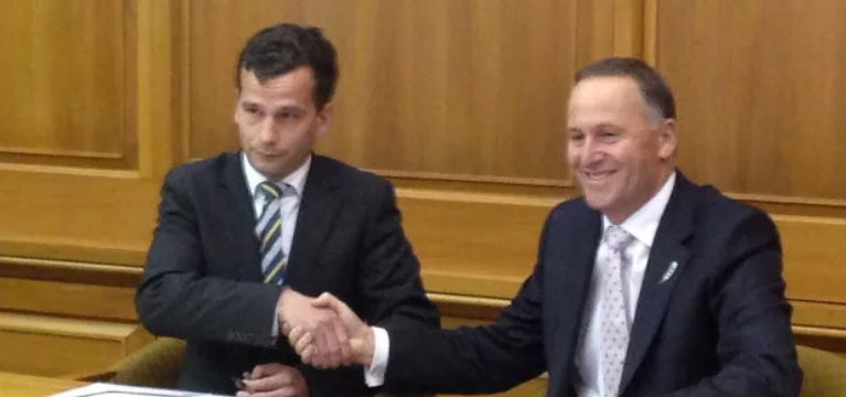 A newly-elected David Seymour shakes hands with former Prime Minister John Key, after signing a confidence and supply agreement with the then National Party-led government. (Photo: RNZ)