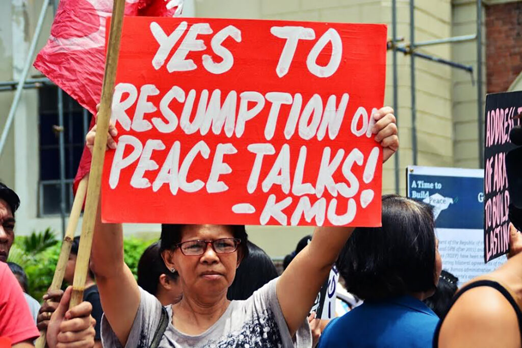A protester with the labour rights group, Kilusang Mayo Uno (KMU), calls for the resumption of peace talks between the CPP-NPA-NDFP and the Government of the Republic of the Philippines.