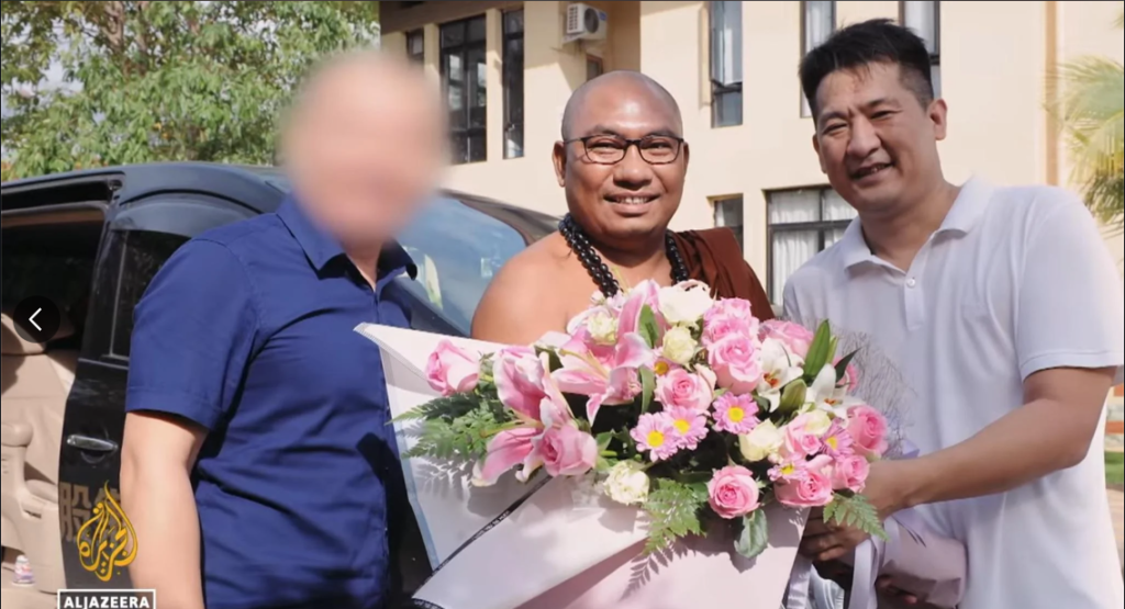 Convicted criminal She Zhijiang (right) is shown in this still from Al Jazeera's 101 East docu-series episode. The man in the left whose face has been blurred is purportedly She's recruiter from China's Ministry of State Security. (Screenshot: Al Jazeera English)