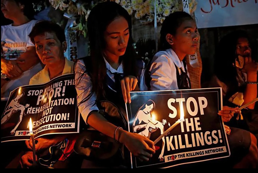 Protesters and residents hold lighted candles and placards at the wake of Kian Loyd delos Santos, a 17-year-old high school student, who was among the people shot dead last week in an escalation of President Rodrigo Duterte's war on drugs in Caloocan city, Philippines. (Photo: Dondi Tawatao/REUTERS)