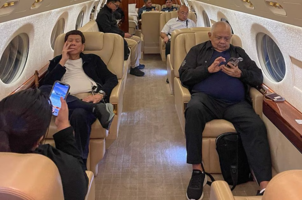 Former president Rodrigo Duterte (seated middle row left) inside the private plane chartered to expatriate him to The Hague, Netherlands. With him is his lawyer and former executive secretary, Salvador Medialdea (seated right, in black). [Photo: ABS-CBN News]