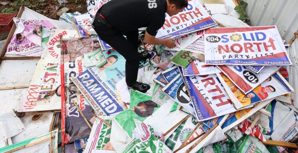 A local government worker takes down campaign posters illegally posted in Quezon City, Philippines. (Photo: Miguel de Guzman/PhilSTAR)