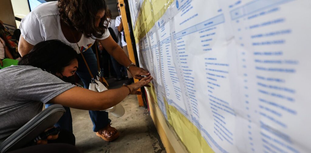 Voters attempt to find their names on the voting roll to determine their polling precinct, a recurring source of stress for Filipinos turning up to vote. (Photo: Getty Images)